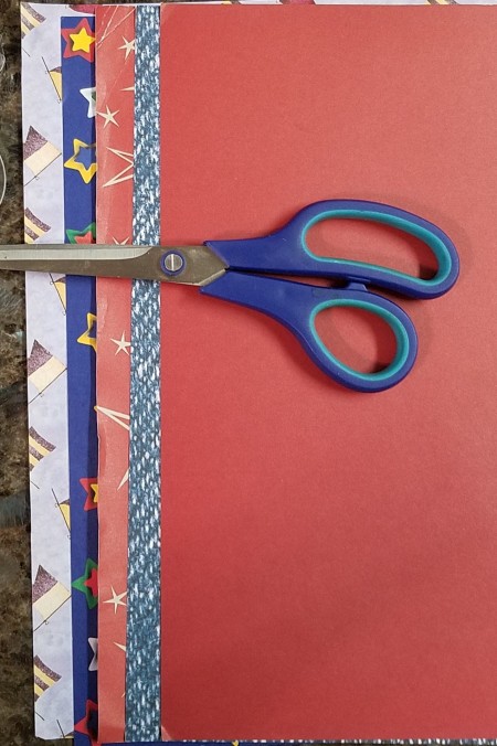 Faux Firecrackers - scissors laying on top of several pieces of scrapbook paper
