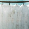 A shower curtain liner hanging from a rod.