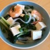 A bowl of bok choy tofu shrimp soup.