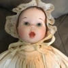 Identifying a Porcelain Doll? - doll wearing a christening dress and bonnet, closeup of the face