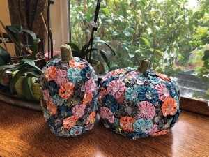 Yo Yo Covered Papier-mâché Pumpkins - pumpkins on antique oak cabinet next to potted orchids
