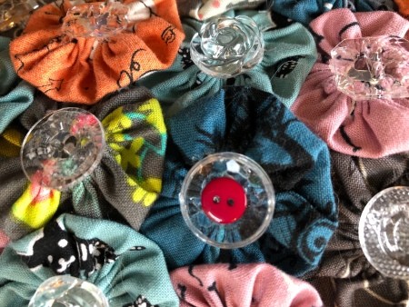 Yo Yo Covered Papier-mâché Pumpkins - closeup of one of the tiny buttons in the center of the cupped clear ones, red