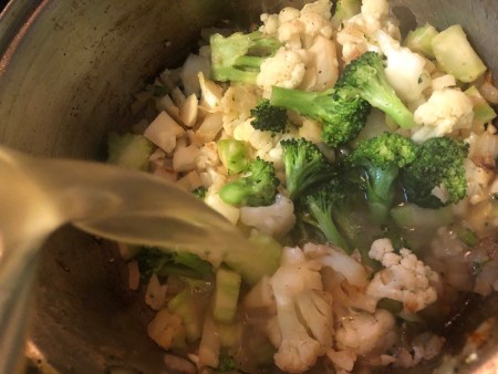 Adding broth to soup pot.