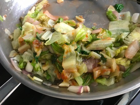 A pan of sauteed romaine lettuce.