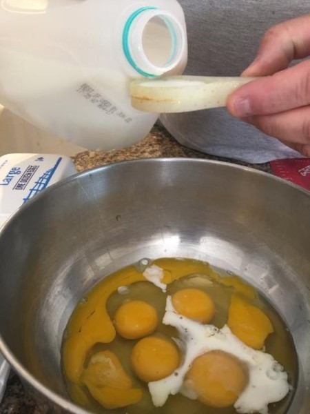 Adding milk to eggs, to make noodles.