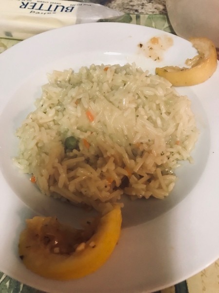 A helping of rice pilaf on a white plate.