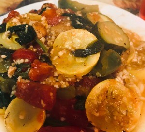 A plate of chicken and vegetables over rice pilaf.