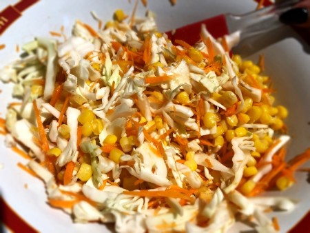 Mixing the coleslaw ingredients together.