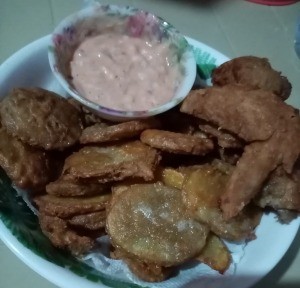 A plate of chicken and mojos with a dipping sauce.