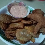 A plate of chicken and mojos with a dipping sauce.