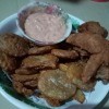 A plate of chicken and mojos with a dipping sauce.