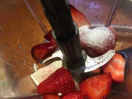 The ingredients for strawberry mousse placed in a blender.