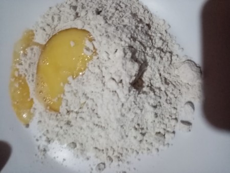 Dredging the egg dipped chicken in flour.