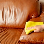 Cleaning a leather sofa with a cloth.