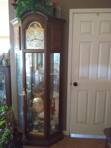 A beautiful grandfather clock next to a door.
