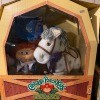 A Cabbage Patch doll and a stuffed horse in a box.