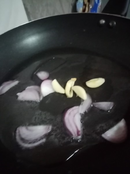 Sauteeing onion and garlic in a frying pan.