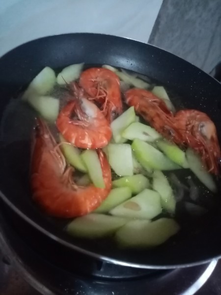 Adding vegetables to the shrimp mixture.