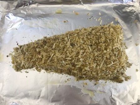 A piece of parmesan breaded cod, before baking.