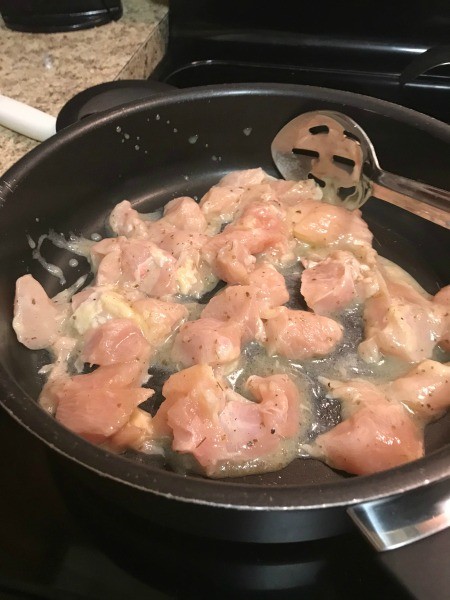Cooking chicken in a cast iron pan.