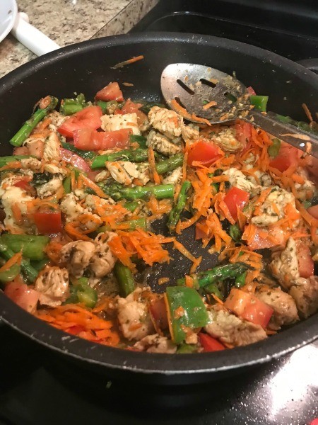 Vegetables added to the chicken in the pan.