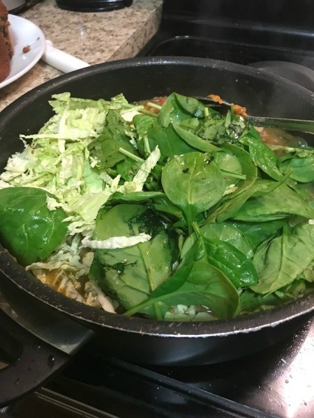 Adding basil to the chicken mixture