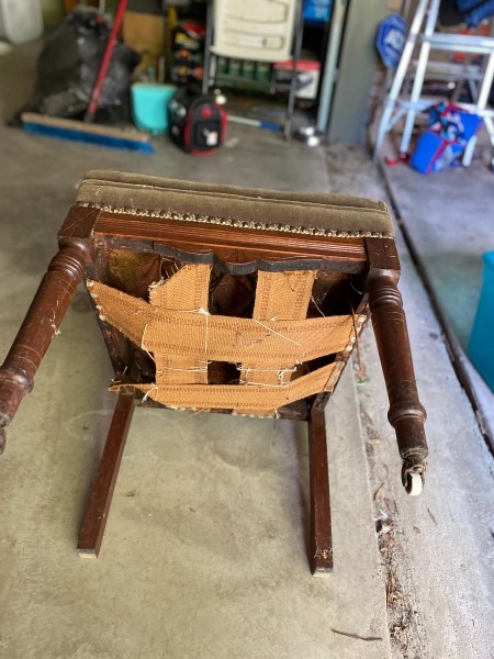 The sagging underside of an antique chair.