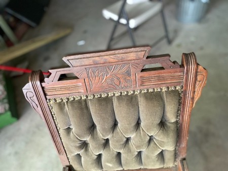 The carved top of an antique chair.