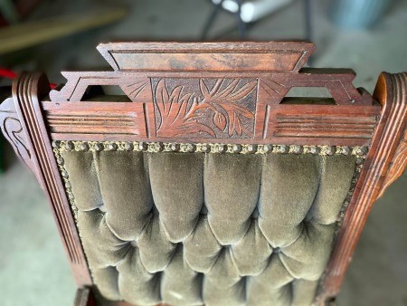 The carved top of an antique chair.
