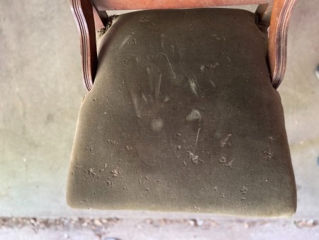 The damaged seat of an antique chair.