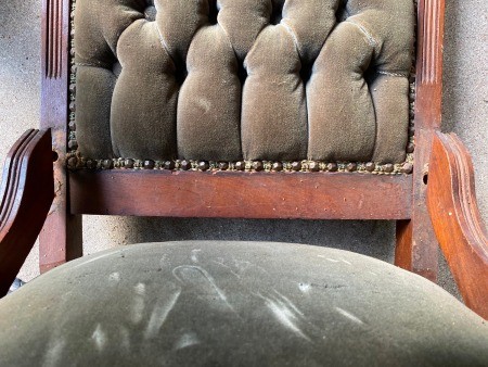 The back and seat of a damaged antique chair.