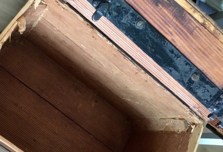 The inside of an old wooden trunk.