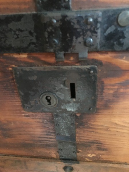 The lock on an old wooden trunk.