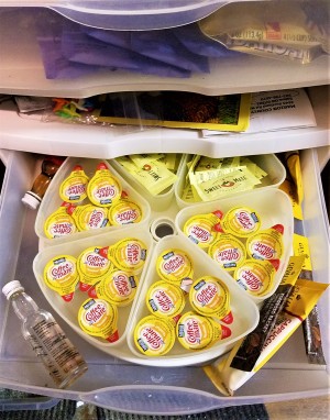 Fridge Spinner for Storage - spinner in a plastic storage drawer filled with creamer single serve packets