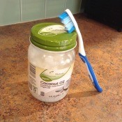 A bottle of coconut oil and a toothbrush.