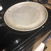 Makeshift Steamer - perforated pizza pan on top of skillet