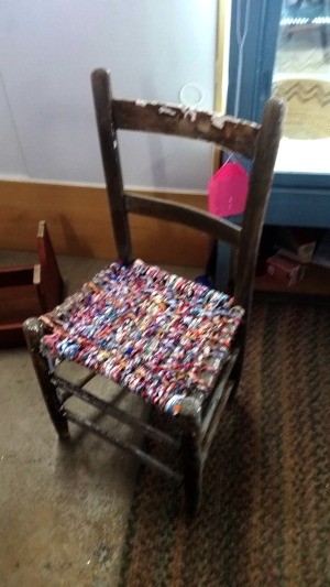 A chair with a woven fabric seat.