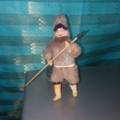 A doll standing holding a hunting spear