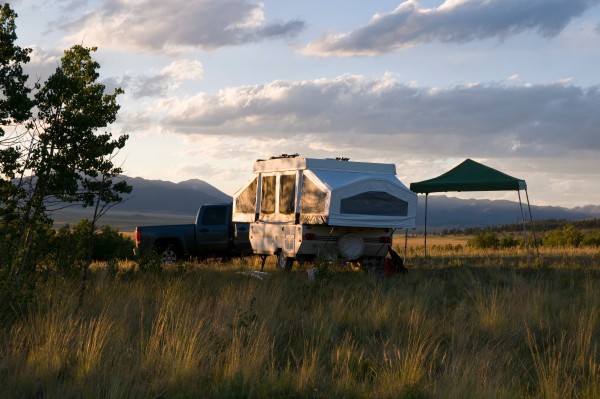 A tent trailer in a field.