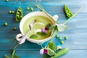 A fresh spring soup in a bowl with flower sprigs.