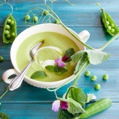 A fresh spring soup in a bowl with flower sprigs.