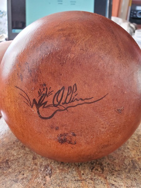 A ceramic pot with a signature on the bottom.