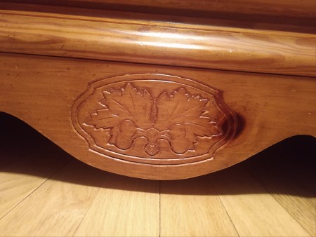 A carving at the base of a Bassett dresser.
