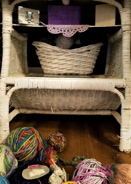 Sprucing Up a TV Stand - small wicker basket on glass and filled with yarn