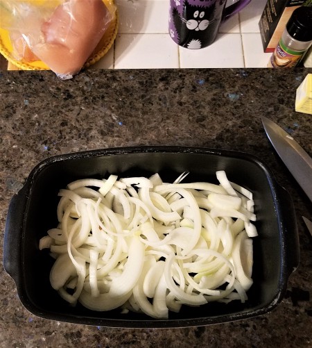 The onion slices placed in a baking pan.