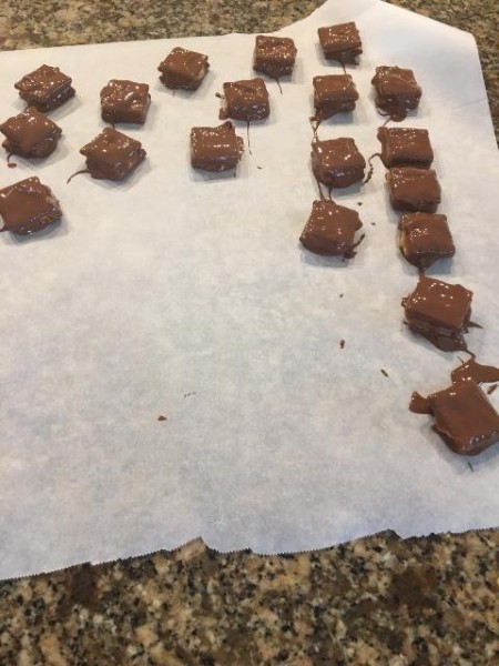 Small bite sized pieces of candy on parchment paper.