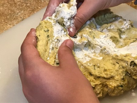 Dandelion Playdough - child kneading in a bit more flour