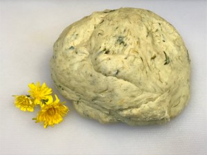 Dandelion Playdough - ball of dough with dandelion flowers next to it