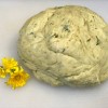 Dandelion Playdough - ball of dough with dandelion flowers next to it