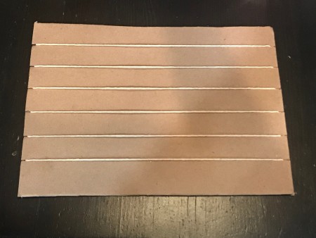 Nature Weaving - string across the front of the cardboard